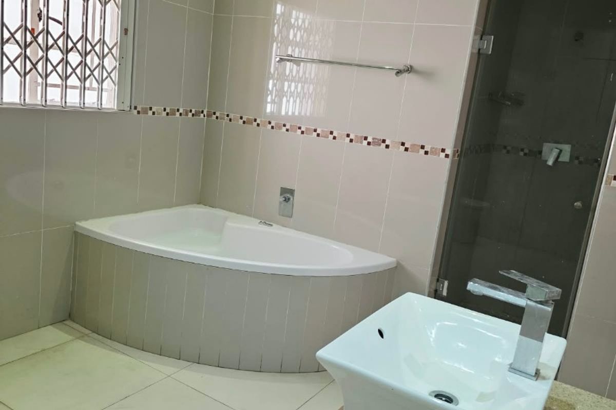 A spacious bathroom featuring a built-in bathtub, double vanity with modern basins, and a separate shower enclosure with a glass door.