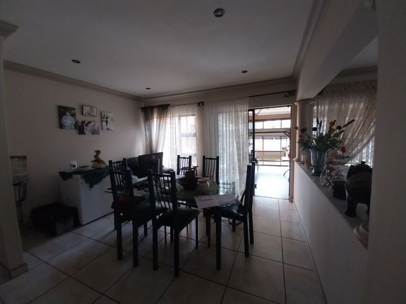 A dining area featuring tiled flooring, recessed lighting, and a sliding glass door providing access to an outdoor patio space.