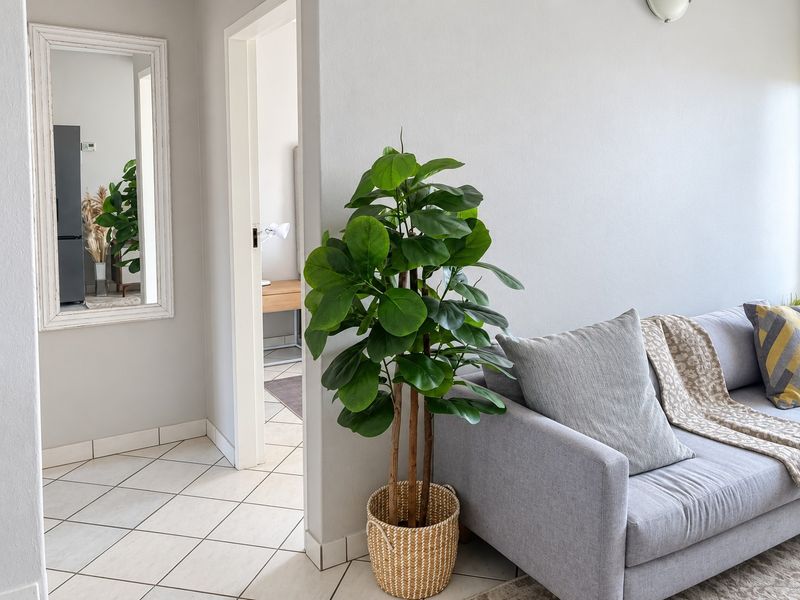 A bright living room area featuring neutral tiled flooring and a clean, well-maintained wall finish, providing a comfortable and inviting atmosphere.