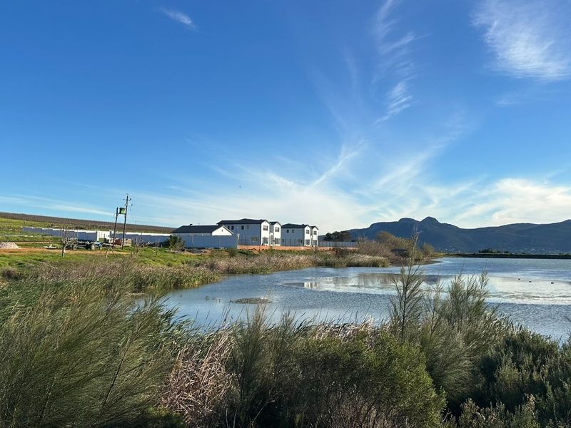 A scenic view of a natural wetland area with a mountain range in the background, showcasing the property's tranquil surroundings.