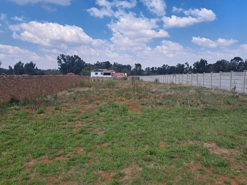 A vacant residential plot featuring established brick and precast concrete boundary walls, ready for development.
