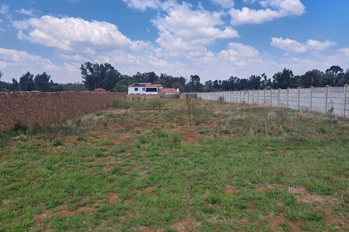 A vacant residential plot featuring established brick and precast concrete boundary walls, ready for development.