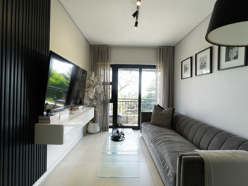 Modern living room featuring sleek slatted wall paneling, a floating media console, tiled flooring, and direct access to a private balcony through sliding glass doors.