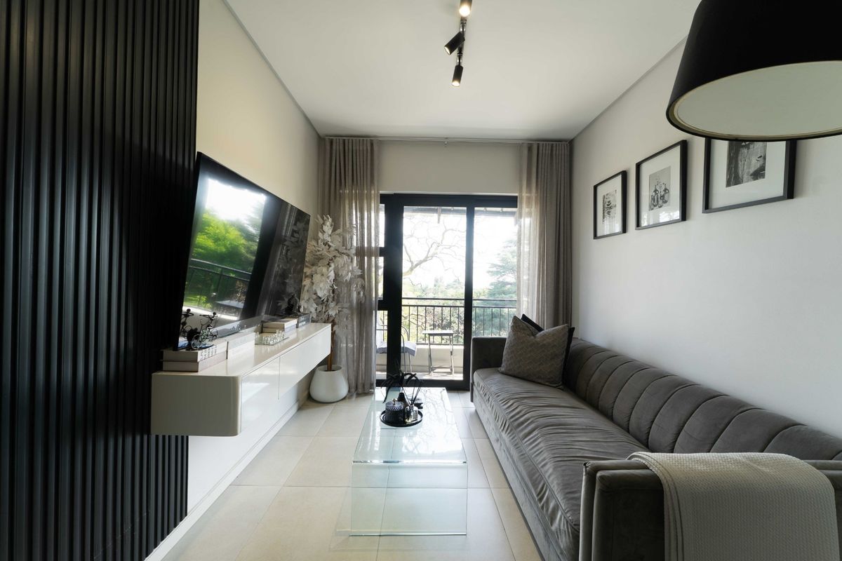 Modern living room featuring sleek slatted wall paneling, a floating media console, tiled flooring, and direct access to a private balcony through sliding glass doors.