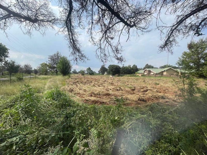 An expansive, undeveloped plot of land on a farm property, featuring cleared vegetation and surrounding rural landscape.