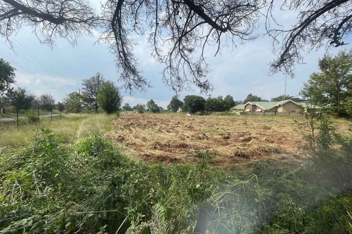 An expansive, undeveloped plot of land on a farm property, featuring cleared vegetation and surrounding rural landscape.