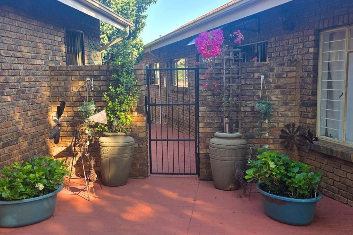 A private rear courtyard featuring face-brick walls, a secure metal gate, and paved flooring, providing a secluded outdoor space.