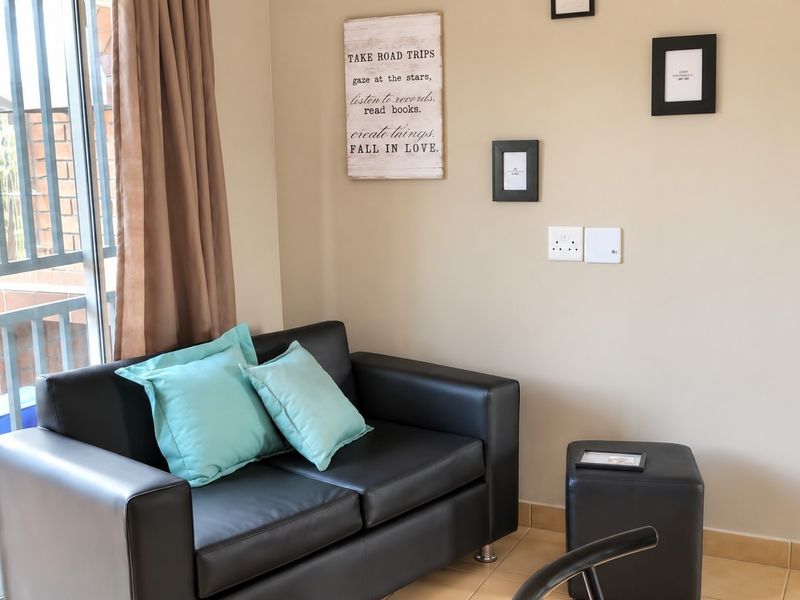 A living area featuring tiled flooring and a sliding glass door providing access to an outdoor space.