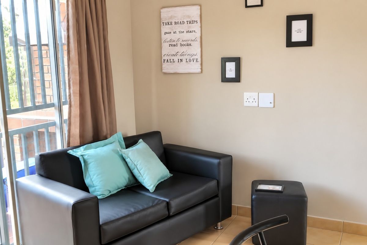 A living area featuring tiled flooring and a sliding glass door providing access to an outdoor space.