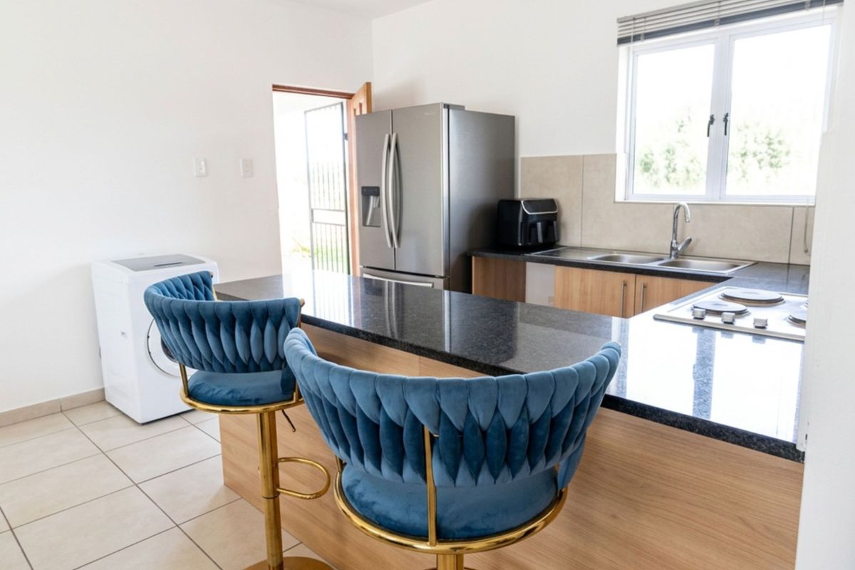 Modern kitchen featuring granite countertops, built-in cabinetry, a gas hob, and a stainless steel sink, with tiled flooring and natural light.