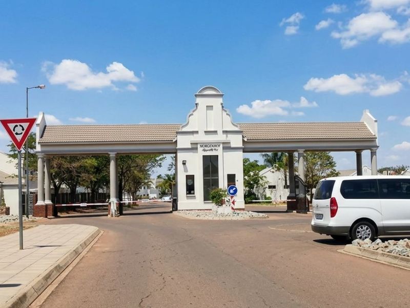 The entrance to the Morgenhof estate featuring a secure gatehouse, boom gate access, and well-maintained architectural columns.