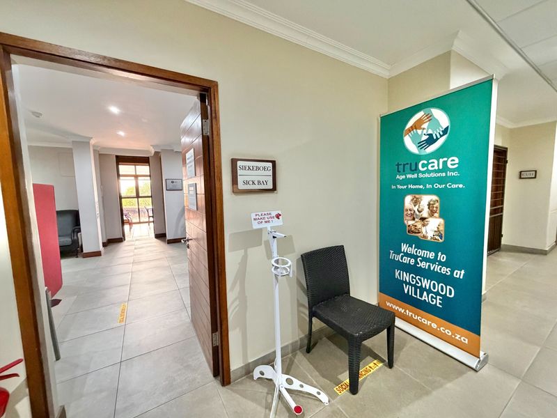 A clean, well-lit hallway entrance leading to a sick bay area with tiled flooring and neutral wall finishes.