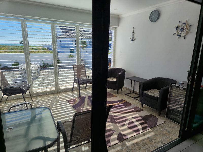 Enclosed patio area featuring tiled flooring, sliding glass doors, and adjustable louvre shutters, offering a bright space with views of the exterior.