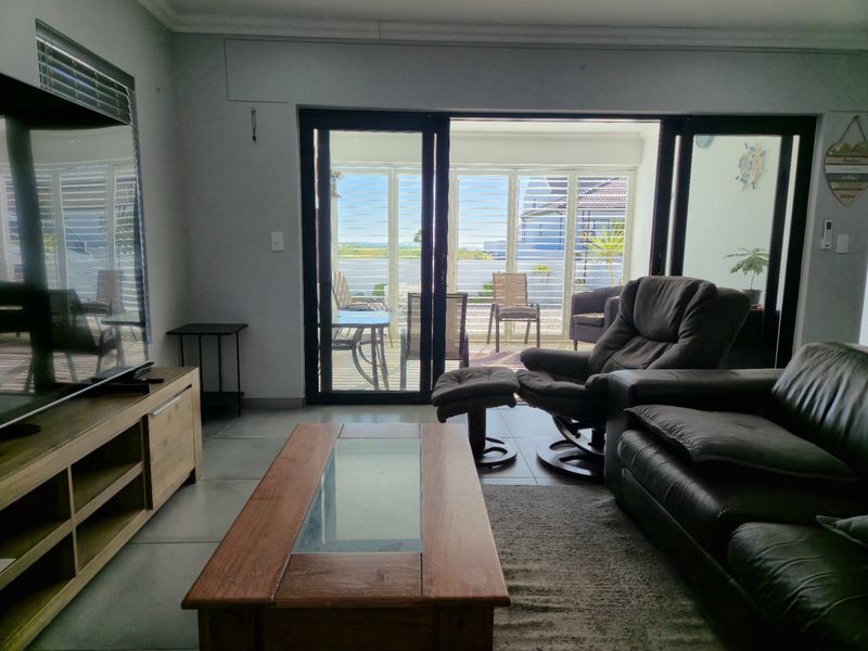 Spacious living room featuring large sliding glass doors that provide natural light and direct access to the outdoor patio area.