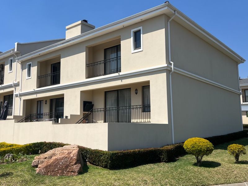 Rear elevation of a multi-story townhouse featuring private balconies with wrought iron railings, sliding glass doors, and well-maintained exterior finishes.
