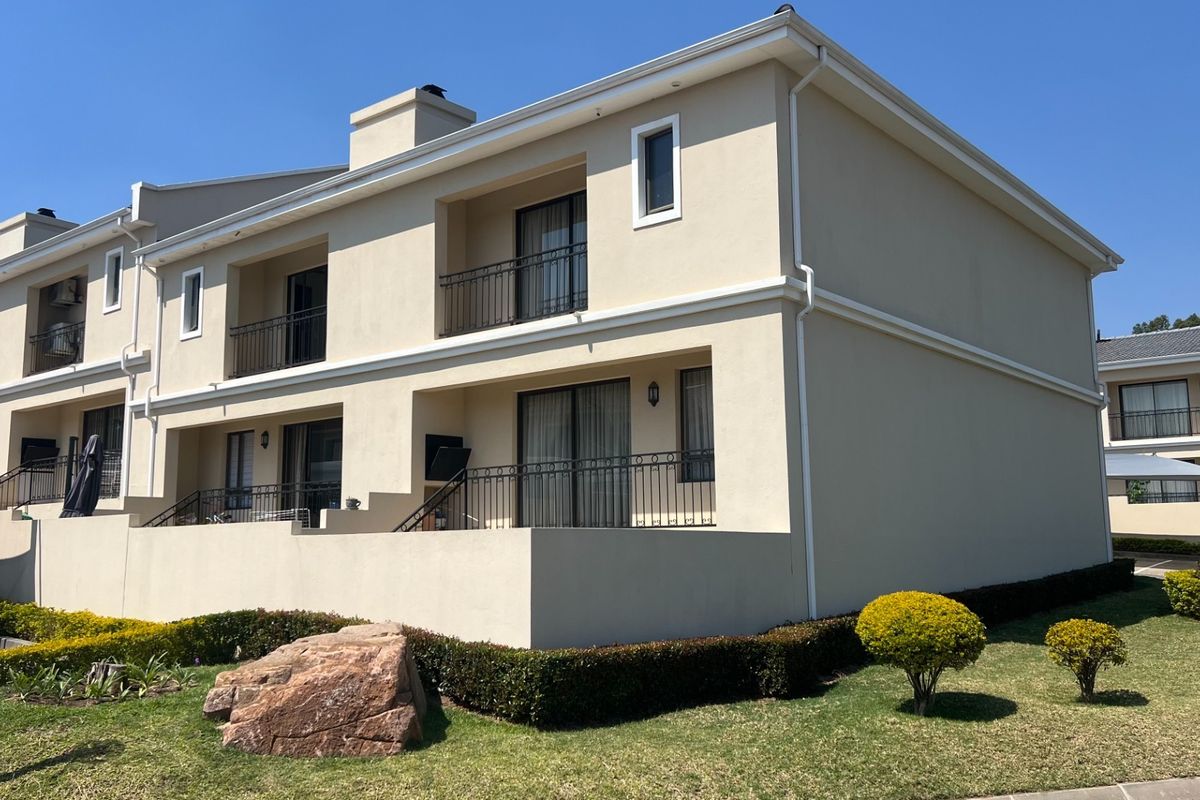 Rear elevation of a multi-story townhouse featuring private balconies with wrought iron railings, sliding glass doors, and well-maintained exterior finishes.