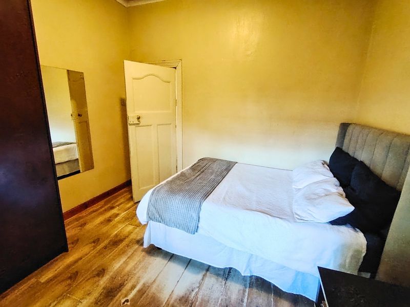 A bedroom featuring timber flooring and a built-in wardrobe, currently requiring cosmetic updates to improve the overall finish and appeal.