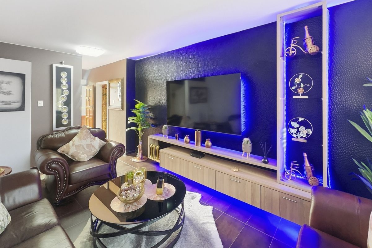 Modern living room featuring a custom built-in media unit with integrated LED accent lighting and dark textured feature wall.