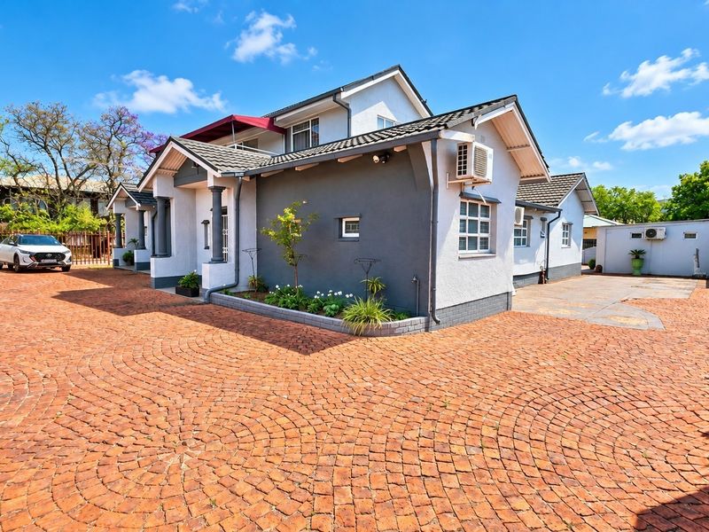 A well-maintained office property featuring a spacious brick-paved driveway, modern exterior finishes, and secure perimeter fencing.