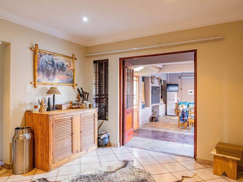 Welcoming entrance hall featuring tiled flooring, decorative columns, and cove cornicing, providing a clear transition into the adjacent living area.
