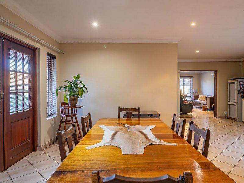 Open plan dining area featuring tiled flooring, recessed lighting, and direct access to the exterior through a wooden door.