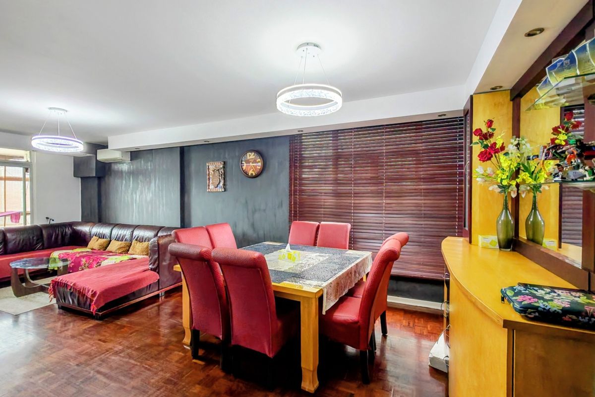 Spacious open-plan living and dining area featuring rich parquet flooring, modern pendant lighting, and built-in cabinetry, creating a functional and versatile living space.