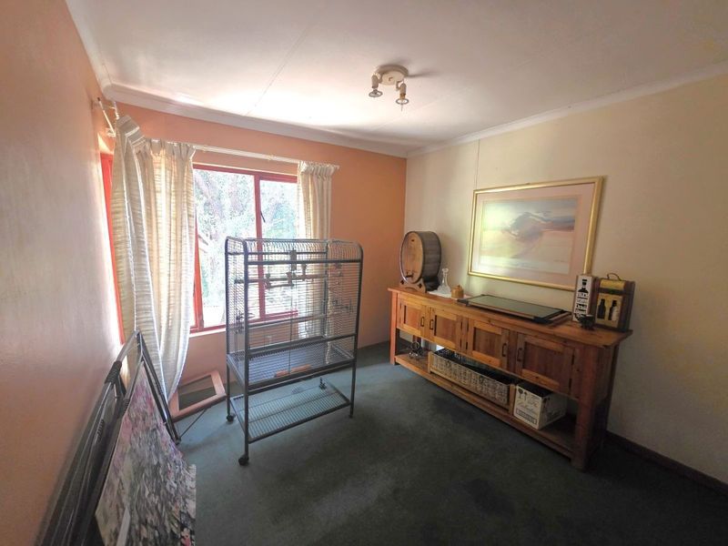A bedroom featuring dated wall finishes and carpet flooring, offering a blank canvas for potential modernization and interior design updates.