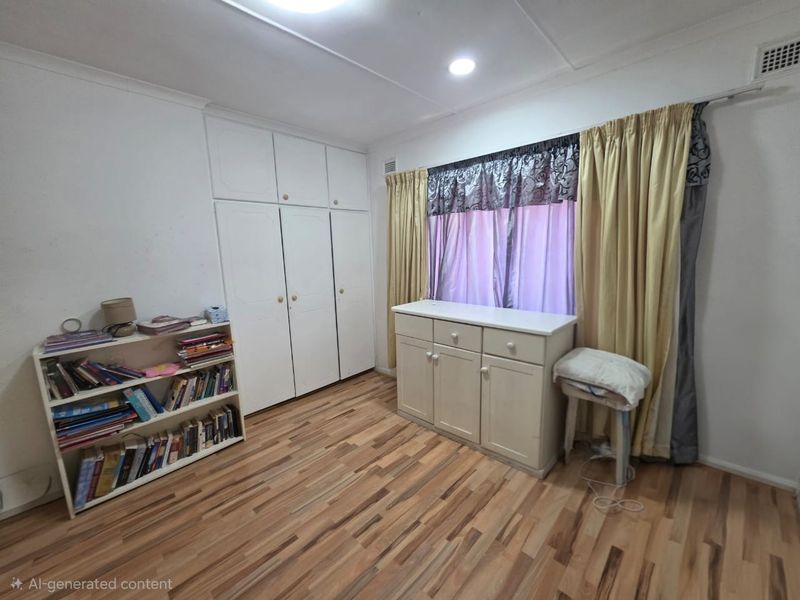 A bedroom featuring built-in cupboards, laminate flooring, and recessed lighting, offering a functional space with neutral finishes.