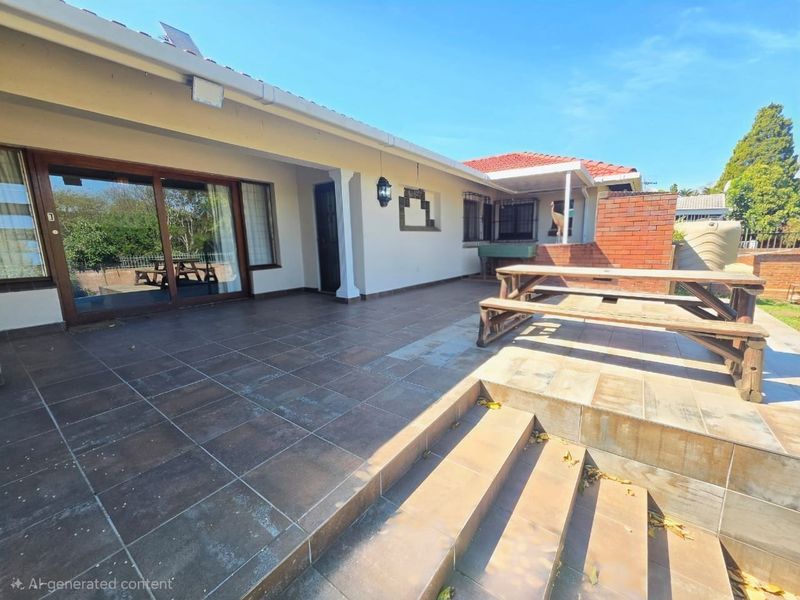 A spacious outdoor patio area featuring tiled flooring, concrete steps, and large sliding glass doors providing seamless access to the home's interior.