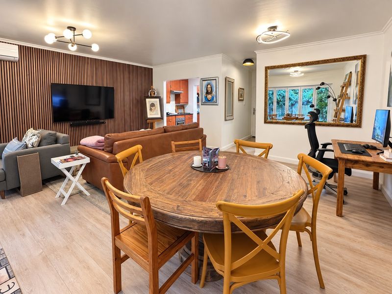 Spacious open-plan living and dining area featuring a modern timber slat feature wall, light laminate flooring, and seamless flow into the kitchen.