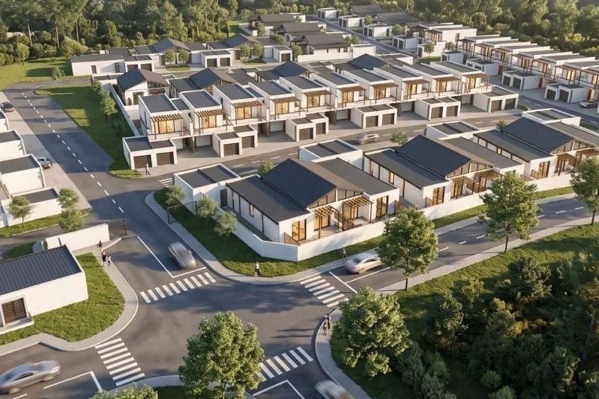 An aerial view of a modern residential estate featuring uniform housing units, paved streets, and landscaped surroundings.
