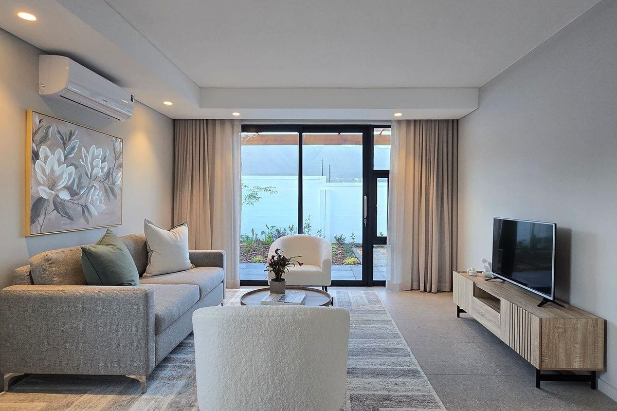 Modern living room featuring tiled flooring, recessed downlighting, a split-system air conditioner, and large sliding glass doors providing access to the outdoor area.