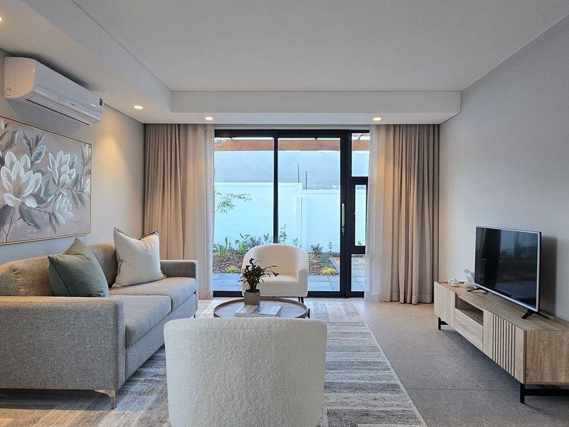 Modern living room featuring tiled flooring, recessed downlighting, a split-system air conditioner, and large sliding glass doors providing access to the outdoor area.