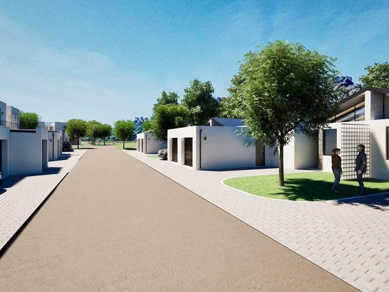 A street-level view of a modern residential development featuring contemporary architectural facades, paved driveways, and landscaped front gardens.