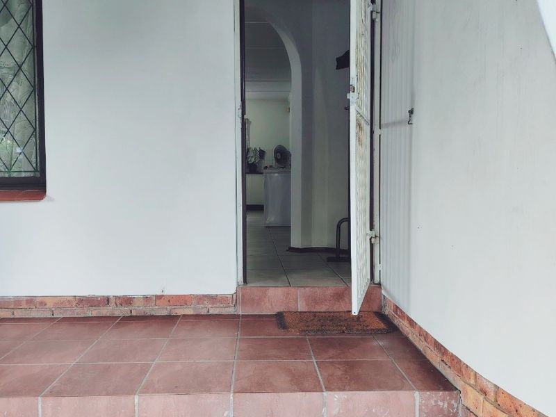 Entrance area featuring tiled steps, a security gate, and a leaded glass window, providing access to the interior living space.