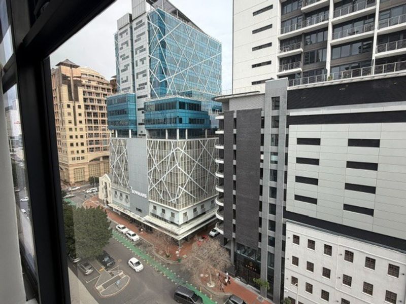 An elevated urban view looking out over a busy city street and surrounding modern commercial office buildings.
