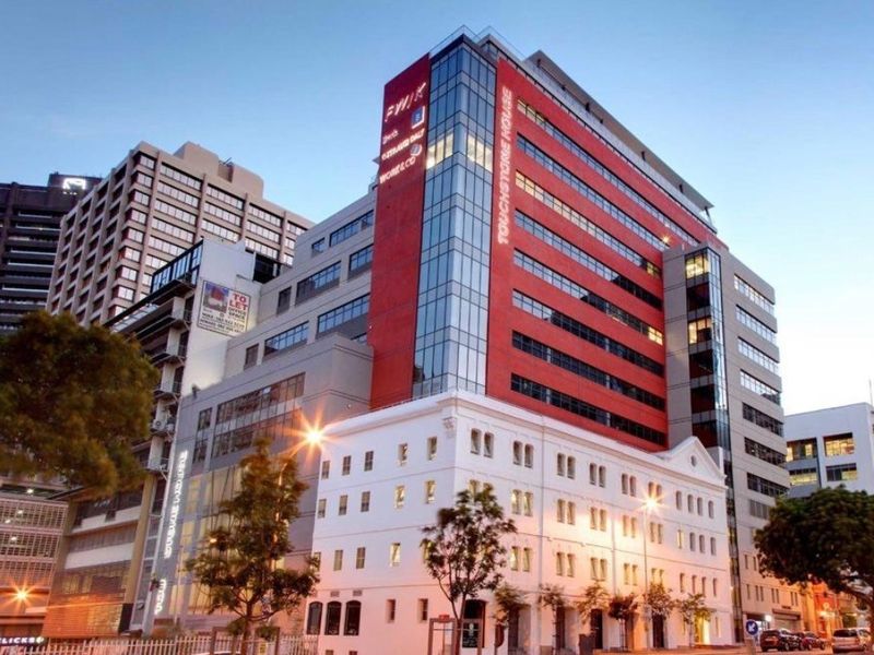 Exterior view of Touchstone House, a modern multi-story commercial office building featuring a prominent glass facade and integrated architectural design.