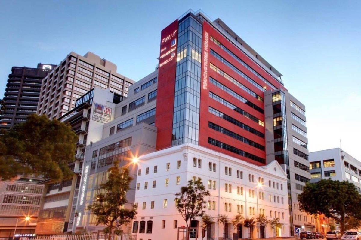 Exterior view of Touchstone House, a modern multi-story commercial office building featuring a prominent glass facade and integrated architectural design.