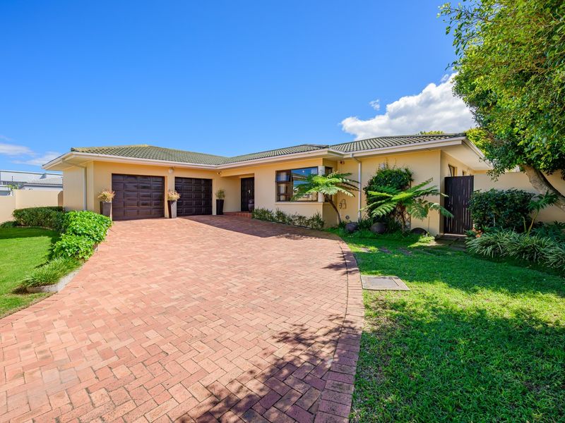 A well-maintained single-story home featuring a brick-paved driveway, double garage, and established garden, presenting a neat and inviting front facade.