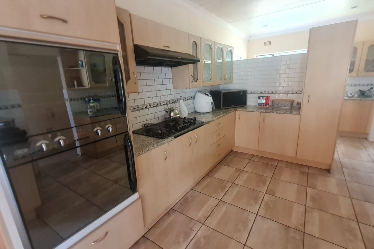 Functional kitchen featuring light wood cabinetry, granite countertops, a built-in oven, gas hob, and a classic subway tile backsplash.