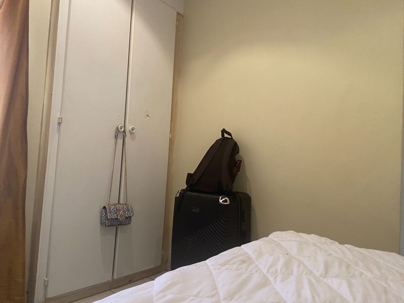 A bedroom featuring a built-in wardrobe with neutral wall finishes, providing functional storage space within the room.