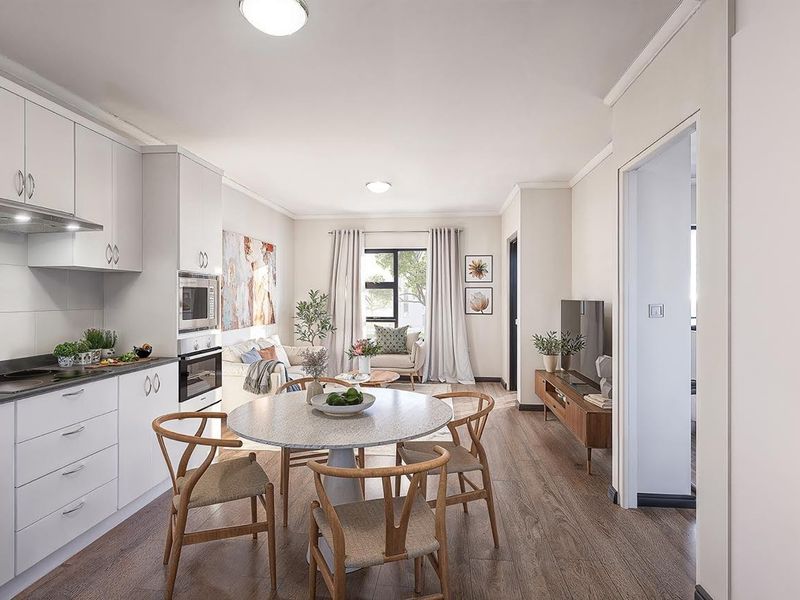 Modern open-plan living area featuring a sleek kitchen with built-in appliances, laminate flooring, and neutral finishes, creating a bright and functional retirement living space.