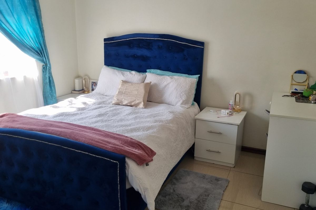 A well-lit bedroom featuring neutral wall finishes and tiled flooring, providing a comfortable and functional living space.