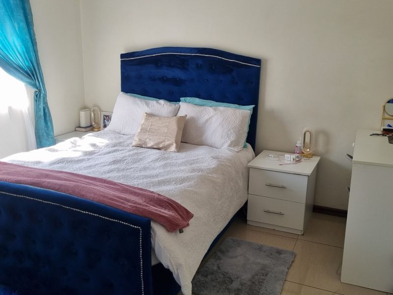 A well-lit bedroom featuring neutral wall finishes and tiled flooring, providing a comfortable and functional living space.