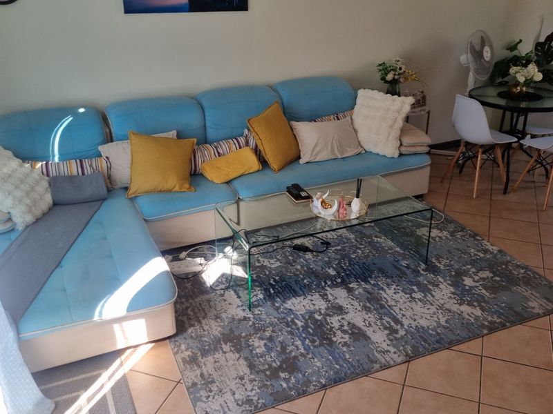 A living room area featuring ceramic floor tiles, providing a functional space for relaxation and dining.