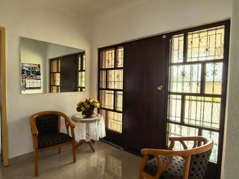 Entrance area featuring tiled flooring, a solid timber door, and integrated security gate, providing a functional and secure welcome to the home.