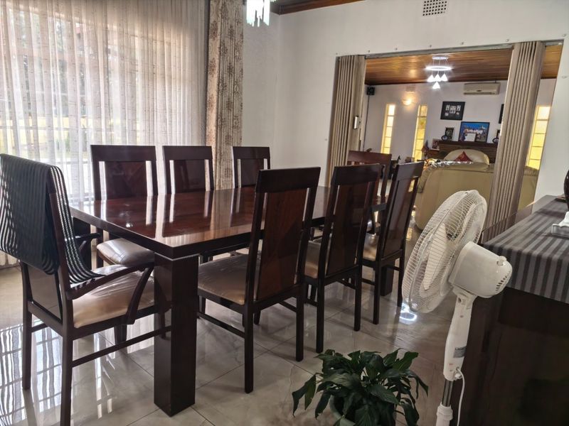 A dining room featuring tiled flooring and a sliding partition door that opens into an adjacent living area.