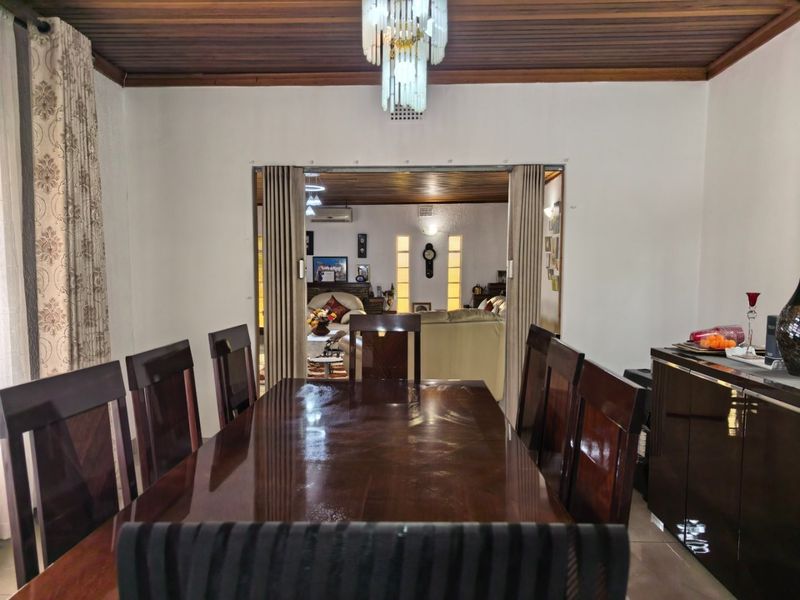 Formal dining room featuring a timber ceiling and a sliding partition door leading into the adjacent living area.