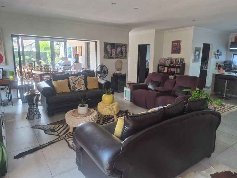 Spacious open-plan living area featuring tiled floors, recessed lighting, and large sliding doors providing seamless access to the outdoor patio.