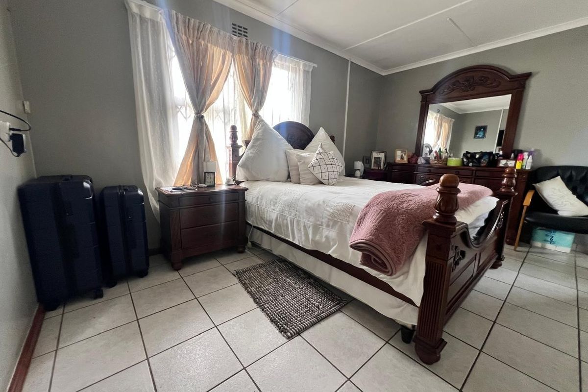 A bedroom featuring tiled flooring and neutral wall finishes, providing a functional space with natural light from the window.